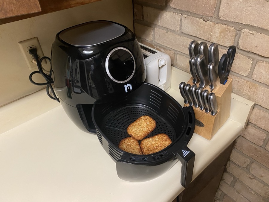 Cosori Pro II air fryer with crispy golden wings in basket